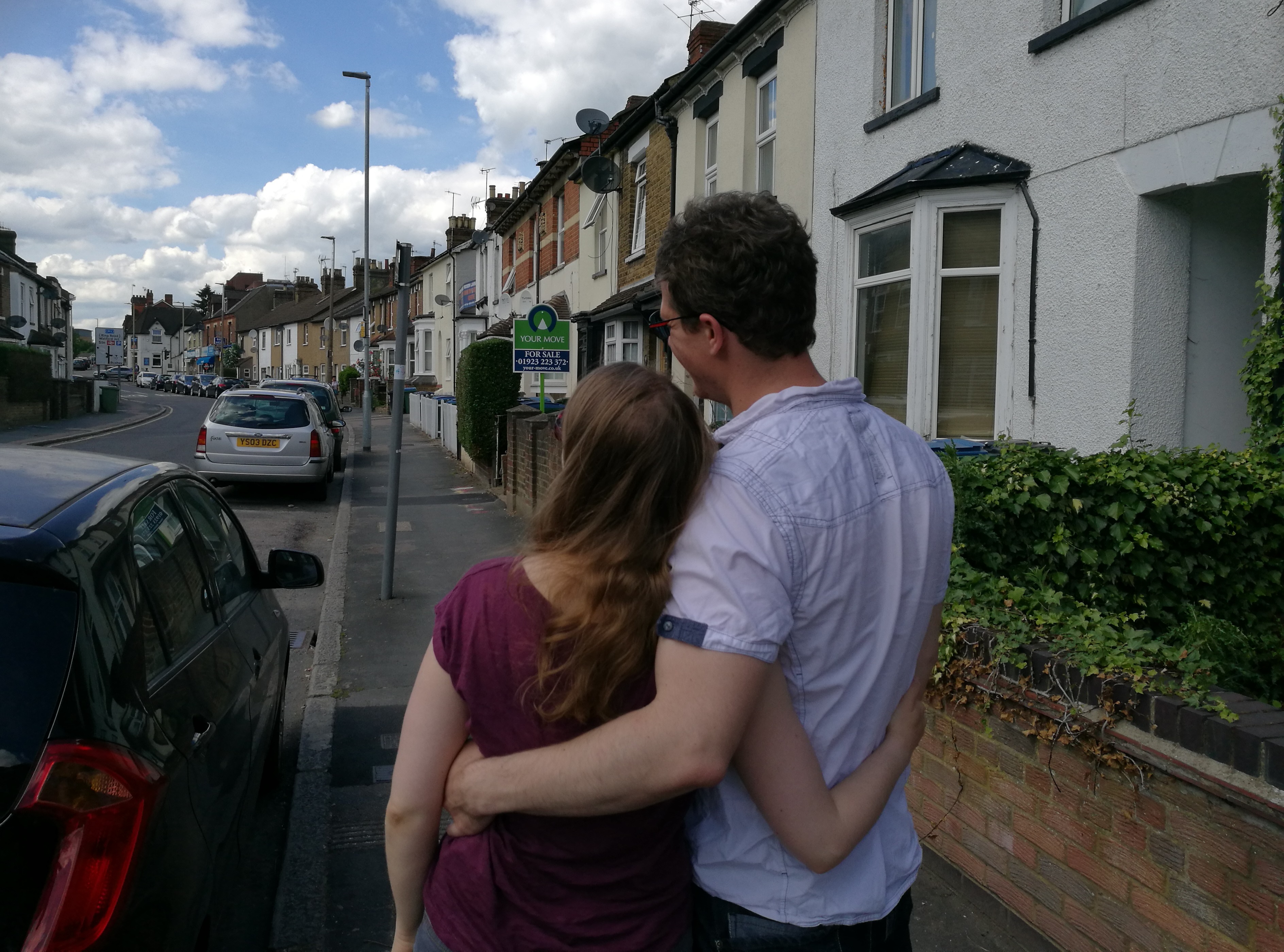 Couple looking sadly at house