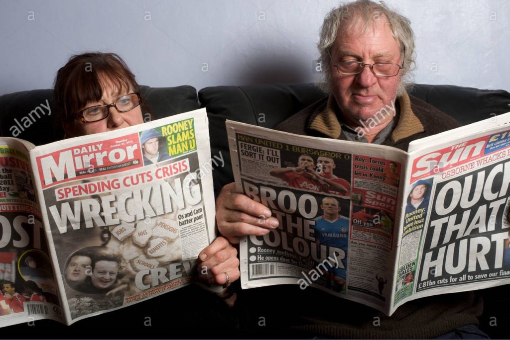 Two old people reading tabloids