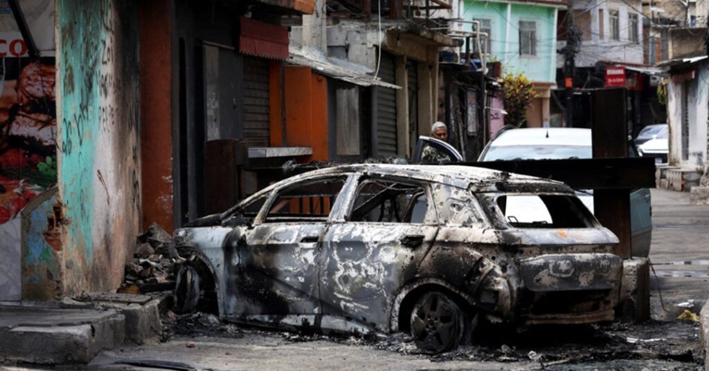 Burnt-out car in Rio favela